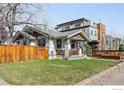 Home with a green lawn, brick border, and a tall wood fence offering a private outdoor space at 4401 Vrain St, Denver, CO 80212