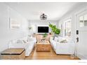 Bright living room shows hardwood floors, white sofas, plants, and a rustic wood coffee table at 4401 Vrain St, Denver, CO 80212