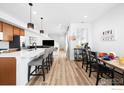 Spacious open-concept kitchen with island seating, modern appliances, and laminate flooring at 47 N Uriah St, Aurora, CO 80018