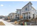 Attractive townhomes line the street, featuring modern designs, inviting front porches, and xeriscaped yards at 47 N Uriah St, Aurora, CO 80018