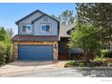 Charming two-story home featuring blue siding, stone accents, and a two-car garage at 5646 Rim Rock Ct, Boulder, CO 80301