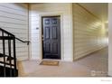 Apartment entryway with welcome mat, black door and stairway to upper levels at 5723 N Gibralter Way # 205, Aurora, CO 80019