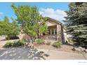 Charming home featuring a stone and siding exterior, a two-car garage, and beautifully landscaped front yard at 6542 S Tempe St, Aurora, CO 80016