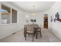 Dining room with large window, modern light fixture, and view of kitchen through arched doorway at 708 Teal Cir, Longmont, CO 80503