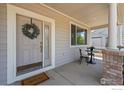 Cozy front porch with seating area, decorative wreath, and charming curb appeal at 708 Teal Cir, Longmont, CO 80503