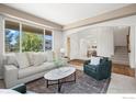 Bright living room featuring neutral paint, a green chair, a gray sofa, and multiple large windows at 708 Teal Cir, Longmont, CO 80503