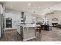 Open-concept kitchen with modern white cabinetry, stainless steel appliances, and granite countertops flowing into the living area at 832 Sundown Way, Erie, CO 80516