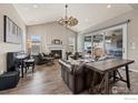 Cozy living room featuring a fireplace, hardwood floors, comfortable leather seating, and lots of natural light at 832 Sundown Way, Erie, CO 80516