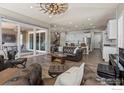 Bright and airy living room featuring a comfortable leather seating, hardwood floors, and an access to the outdoor terrace at 832 Sundown Way, Erie, CO 80516