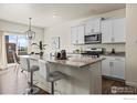 Bright kitchen featuring a granite-topped island with a breakfast bar and stainless steel appliances at 902 William Way, Brighton, CO 80603