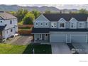 Exterior shot of townhome, including garage and well-maintained landscaping, with beautiful mountain views in the background at 919 Russell St, Golden, CO 80401