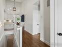 Upstairs hallway featuring wood floors, white trim, and arched entryway at 950 Sumner Way, Erie, CO 80516