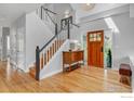 Bright foyer with hardwood floors, staircase with white railings, and a wooden door with glass panels at 982 Walnut Ct, Louisville, CO 80027