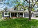 Inviting home featuring a covered porch, manicured lawn, and attached two-car garage at 982 Walnut Ct, Louisville, CO 80027