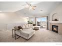 Bright living room boasts a fireplace, a ceiling fan, and a sliding glass door to the outside at 10818 Cimarron St # 206, Firestone, CO 80504