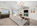 Comfortable living room featuring a fireplace, mounted television, and view to the outside at 10818 Cimarron St # 206, Firestone, CO 80504