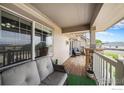 Covered porch with seating, stone columns, and view of the neighborhood at 10818 Cimarron St # 206, Firestone, CO 80504