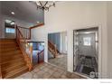 Welcoming foyer features a staircase, tile flooring, and mirrored closet doors at 1241 River Glen Way, Berthoud, CO 80513