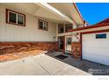 Inviting front entrance showcasing brick accents, large windows, and covered entryway at 1241 River Glen Way, Berthoud, CO 80513