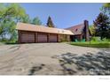 Exterior view showcasing a three-car garage and stone accents and the unique design of the home at 12855 N 66Th St, Longmont, CO 80503