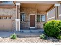 Charming brick home featuring a covered porch and well-maintained landscaping at 13972 Monroe St, Thornton, CO 80602