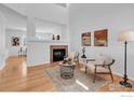 Bright living room with vaulted ceiling, modern fireplace, and hardwood floors at 13972 Monroe St, Thornton, CO 80602