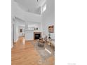 Bright living room with vaulted ceiling, modern fireplace, and open floorplan at 13972 Monroe St, Thornton, CO 80602