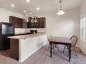 Cozy kitchen and dining area featuring dark wood cabinets and neutral countertops, providing ample space at 1456 Sepia Ave, Longmont, CO 80501