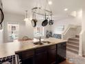 Kitchen with stainless steel appliances, eat-in island, and pot rack at 1456 Sepia Ave, Longmont, CO 80501