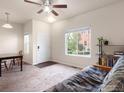 Cozy living room with a large window, ceiling fan, and neutral-toned carpet at 1456 Sepia Ave, Longmont, CO 80501