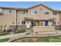 Tan townhouse with a front patio area and beautiful landscaping with rock accents at 1601 Great Western Dr # D3, Longmont, CO 80501