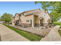 Townhouse exterior showcasing well-kept landscaping, a small patio, and a sidewalk at 1601 Great Western Dr # D3, Longmont, CO 80501