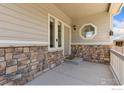 Inviting front porch with stone accents and stylish exterior lighting at 1705 Wales Dr, Berthoud, CO 80513
