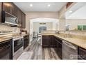 Well-equipped kitchen with stainless steel appliances, granite countertops, and dark wood cabinets at 1705 Wales Dr, Berthoud, CO 80513