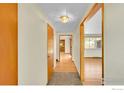 Hallway with light-colored walls and trim, wood doors, and hardwood floors at 1800 Atwood St, Longmont, CO 80501