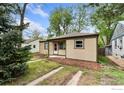 A single-story house with neutral siding, a well-kept yard with mulch, and a concrete walkway to the front door at 2022 Ford St, Golden, CO 80401