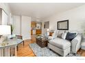 Cozy living room with hardwood floors, a stylish sectional sofa, and an open view into the adjacent kitchen at 2022 Ford St, Golden, CO 80401