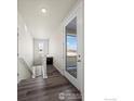 Bright hallway with wood floors, leading to a balcony and stairs at 350 High Point Dr # 201, Longmont, CO 80504