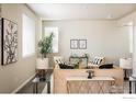 Bright living room with modern decor, large windows, hardwood floors, and neutral color palette at 360 Marlowe Ct, Erie, CO 80516
