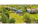 Aerial shot of a spacious backyard with a deck, fire pit area, mature trees and lush greenery at 3715 E 139Th Pl, Thornton, CO 80602