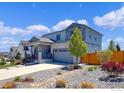 Attractive two-story house with a gray facade, stone accents, covered porch, and a landscaped front yard at 6506 Merrimack Dr, Castle Pines, CO 80108