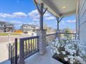 Inviting front porch featuring stone pillars, decorative railings, and a serene view of the neighborhood at 6506 Merrimack Dr, Castle Pines, CO 80108