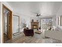 Sun-filled living room with hardwood floors and a cozy stone fireplace at 7820 W 87Th Dr # K, Arvada, CO 80005