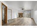 Bright living room with hardwood floors, fan, and stone fireplace at 7820 W 87Th Dr # K, Arvada, CO 80005