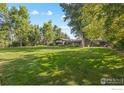 Expansive backyard with lush lawn and mature trees provides ample space for outdoor activities at 819 Gapter Rd, Boulder, CO 80303