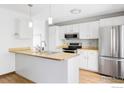 Bright kitchen features stainless steel appliances, white cabinets, and a breakfast bar, perfect for casual dining at 1013 Alsace Way, Lafayette, CO 80026