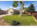 Well-maintained front yard with lush green grass and decorative trees showcasing curb appeal at 1030 S Fulton Ave, Fort Lupton, CO 80621