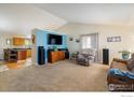 Cozy living room featuring plush carpeting, entertainment center, and comfortable seating at 1030 S Fulton Ave, Fort Lupton, CO 80621