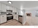 Modern kitchen features white cabinets, stainless steel appliances, and peninsula island at 12525 E Tennessee Cir # E, Aurora, CO 80012