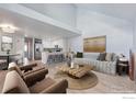 Bright living room with vaulted ceiling, wood floors, modern furniture, and open to the kitchen at 12525 E Tennessee Cir # E, Aurora, CO 80012